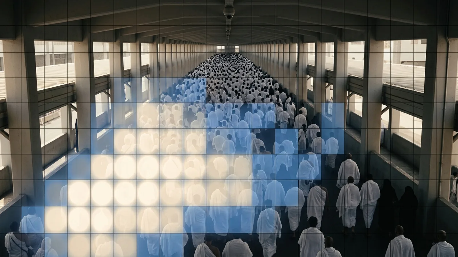 A fixed-camera view down a crowded covered walkway with a translucent grid heat-map overlaid, brightest where the crowd is densest